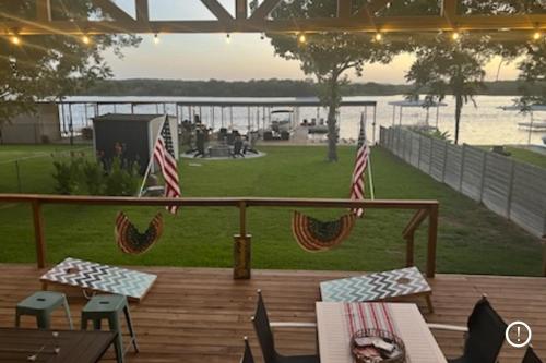 a deck with two american flags and a view of the water at Dockside Digs in Kingsland