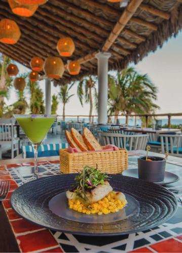 a plate of food on a table with a drink at Mar del Cabo By Velas Resorts Adults Only in San José del Cabo