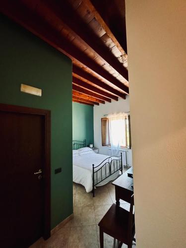 a bedroom with a bed and a green wall at Valdorcia Belvedere b&b in Pienza