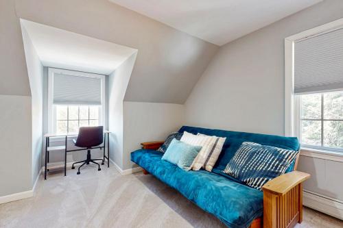 a living room with a blue couch and a desk at Kindred Hollow in Ludlow