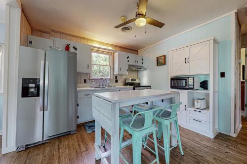 a kitchen with a refrigerator and two stools in it at Remy's Reef in Salvo