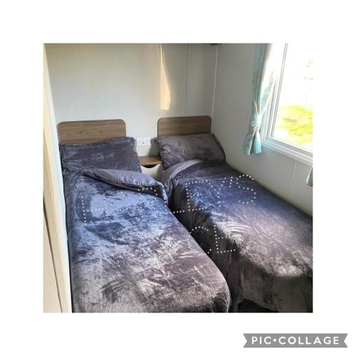 2 Betten in einem Zimmer mit Fenster in der Unterkunft 3 bedroomed CH Caravan on Presthaven Beach Resort in Talacre
