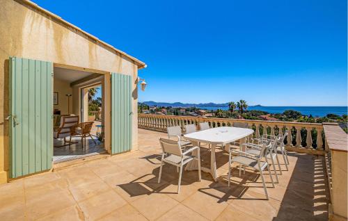 un patio avec une table et des chaises et l'océan dans l'établissement Pet Friendly Home In Saint Aygulf, à Saint-Aygulf
