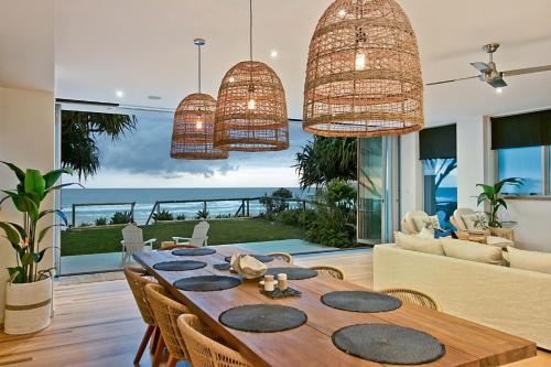 Beachfront Bliss في غولد كوست: غرفة طعام مع طاولة وإطلالة على المحيط