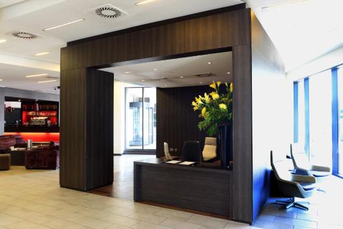 an office lobby with a reception desk with a plant at Crowne Plaza Birmingham City by IHG in Birmingham