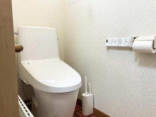 a bathroom with a white toilet and a remote control at Yamabe Blue in Furano