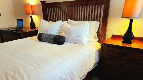 a hotel room with a bed with white sheets and pillows at Wine Country Reserves in Murrieta