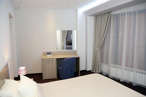 a bedroom with a desk and a bed and a mirror at Parliament Square in Bucharest