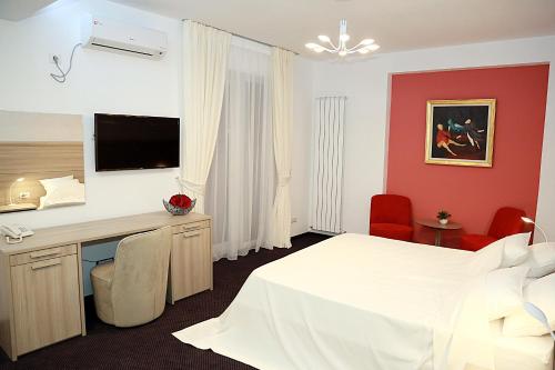 a hotel room with a white bed and a desk at Parliament Square in Bucharest