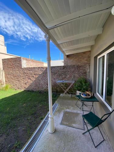 a patio with a table and chairs under a roof at Jencquel Home in Coronel Suárez