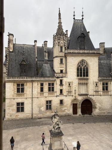 un grand bâtiment avec une statue devant lui dans l'établissement Résidence Jacques Coeur, à Bourges