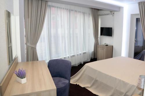 a hotel room with a table and chairs and a window at Parliament Square in Bucharest