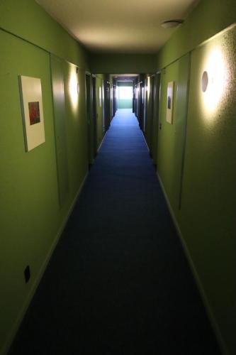 a long hallway with green walls and a long hallway at Strassen Hotel in Goiânia