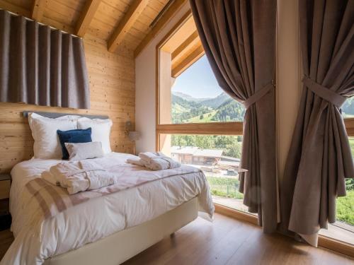 une chambre avec un lit et une grande fenêtre dans l'établissement Chalet in Megève with Mont-Blanc Views, à Praz-sur-Arly