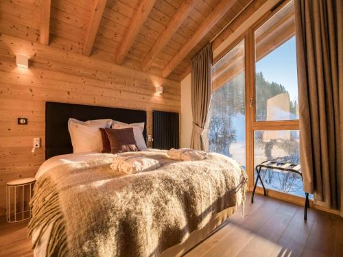 une chambre avec un grand lit avec une grande fenêtre dans l'établissement Chalet in Megève with Mont-Blanc Views, à Praz-sur-Arly