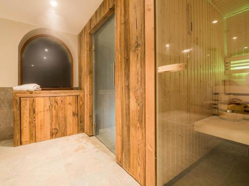 La salle de bains est pourvue d'une télévision et d'une douche en verre. dans l'établissement Chalet in Megève with Mont-Blanc Views, à Praz-sur-Arly