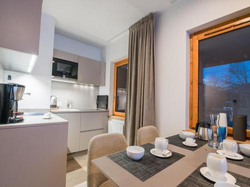 une cuisine et une salle à manger avec une table et des chaises dans l'établissement Chalet in Megève with Mont-Blanc Views, à Praz-sur-Arly