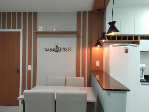 a kitchen with a table and chairs and a refrigerator at Aconchego de Espírito Santo do Pinhal in Espirito Santo Do Pinhal