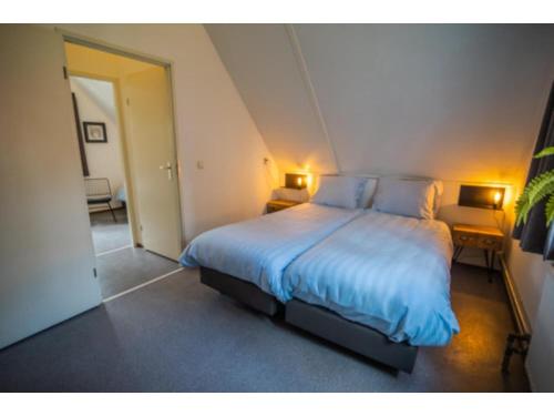 Un dormitorio con una cama grande con sábanas azules. en Forest Villa in Markelo with Sunny Garden, en Markelo