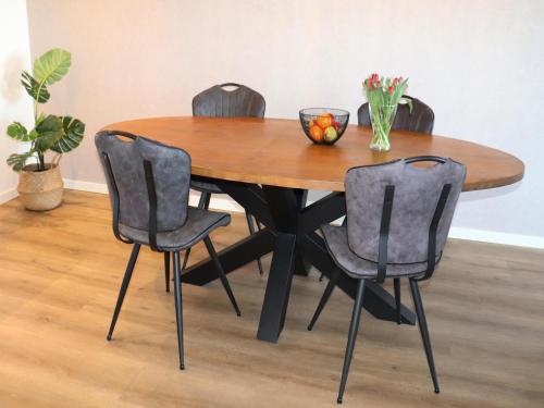 a wooden table with four chairs and a bowl of fruit on it at Apartment in Workum near IJsselmeer Beach in Workum