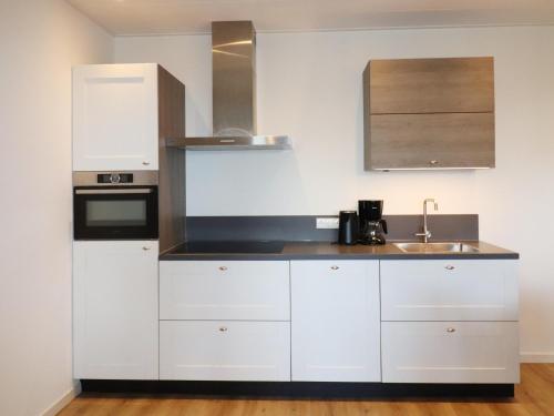 a kitchen with white cabinets and a sink at Apartment in Workum near IJsselmeer Beach in Workum
