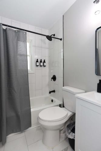 a white bathroom with a toilet and a shower at New Charloe Court 3 Bed Family House in Cincinnati