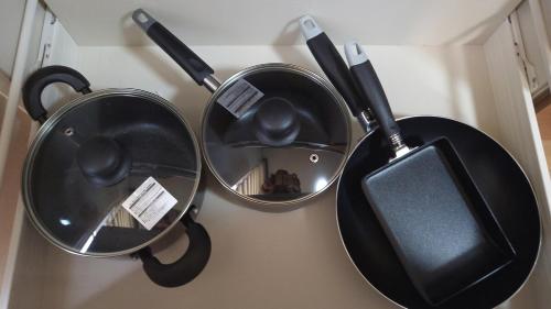 three pots and pans hanging on a wall at BEPPU つばき 一棟貸切宿 鉄輪温泉まで車で4分 石風呂付 無料駐車場3台 最大6名 wifi無料 in Beppu