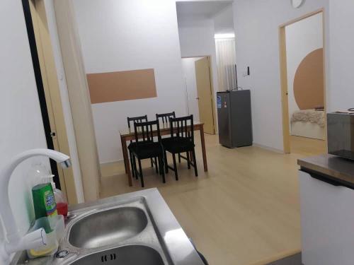 a kitchen with a sink and a table and chairs at Comfy house in Melaka City Centre in Malacca
