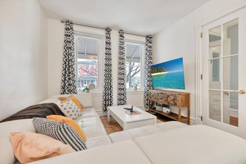 Una sala de estar con un sofá blanco y una ventana. en Downtown Lancaster Luxury 4BR - Garage & Parking, en Lancaster