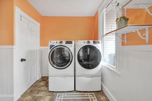 a washer and dryer in a laundry room with an orange wall at Downtown Lancaster Luxury 4BR - Garage & Parking in Lancaster