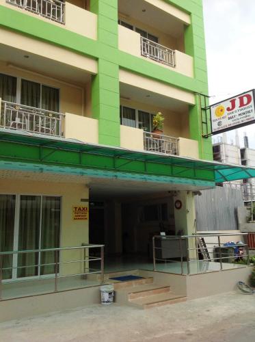 a building with a green and white building at JD Guesthouse in Pattaya