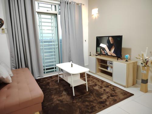 ein Wohnzimmer mit Sofa und Fernseher in der Unterkunft Tebrau City Residence by Natol in Johor Bahru