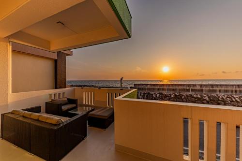 SUNSETCHURAー海が見える宿ーA relaxing momentにあるバルコニーまたはテラス