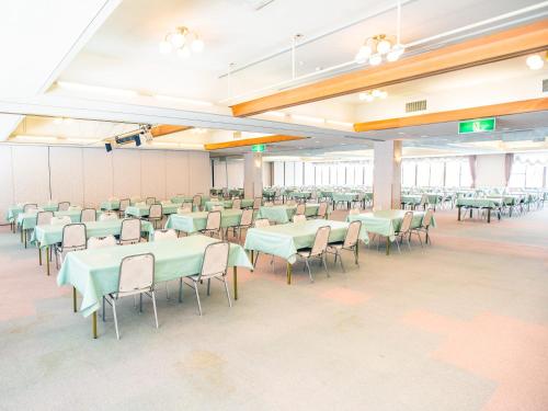 a banquet hall with tables and chairs in a room at Kurohime Kogen Hotel in Shinano