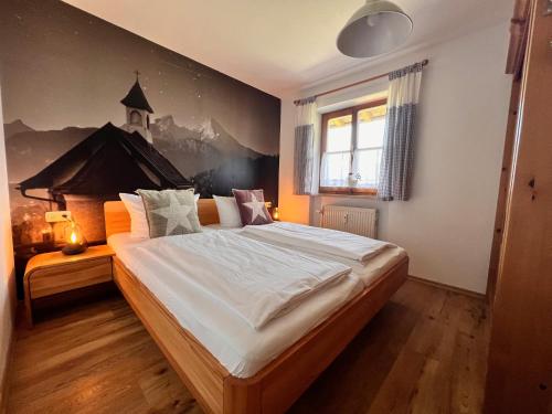 a bedroom with a large bed with a painting on the wall at Ferienwohnung Sonnenglück in Schönau am Königssee
