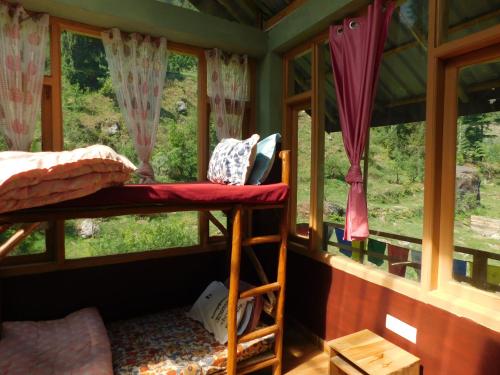a bedroom with a bunk bed and a window at The Sigiriya Old manali in Manāli