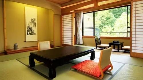 a living room with a black table and chairs at 川俣仙心亭ホテル in Nikko