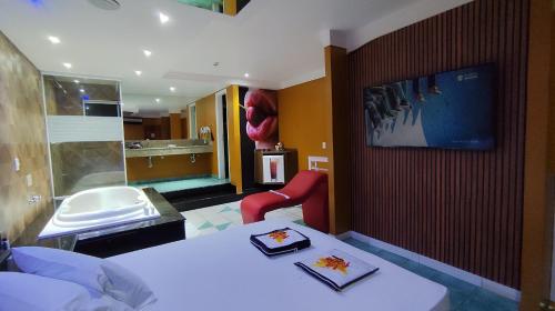 a hotel room with a bed and a tv on a wall at MOTEL LA FOLIA in Ribeirão Preto