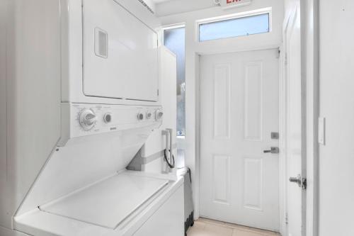 a white kitchen with a sink and a white door at Updated 1 BR Home - Steps to 7th Ave in Tampa