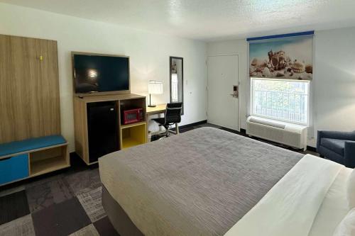 ニスビルにあるDays Inn by Wyndham Eglin AFBのベッドと薄型テレビがあるホテルの部屋