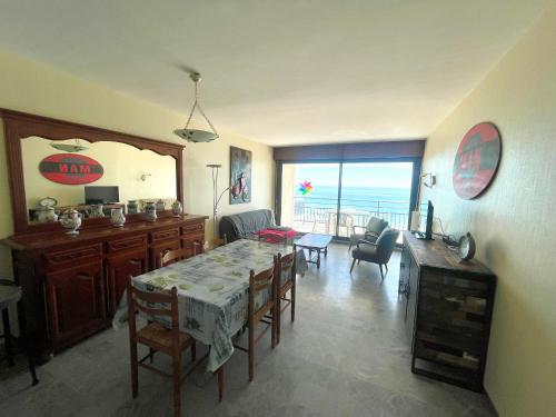 une salle à manger avec une table et une chambre avec l'océan dans l'établissement Face Océan : T3 au 9ème avec Balcon-Terrasse, Centre Plage et Ville, Tout Confort - FR-1-92-645, à Les Sables-dʼOlonne
