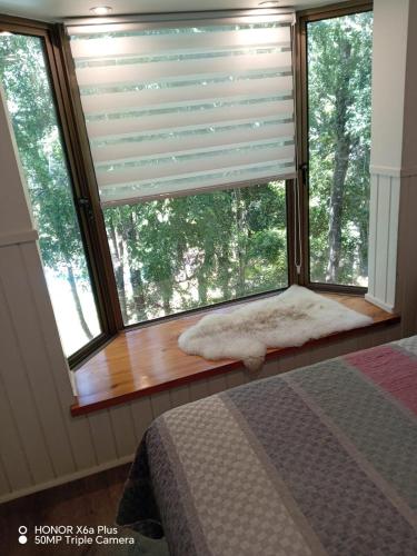 a window in a bedroom with a window blind at Departamento en Pucón in Pucón