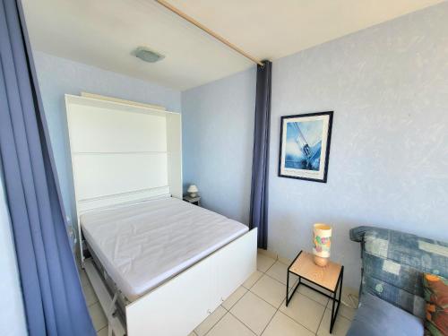 une petite chambre avec un lit et un canapé dans l'établissement Charmant studio avec balcon, animaux acceptés, parking privé, proche plage et commerces - FR-1-92-915, à Les Sables-dʼOlonne
