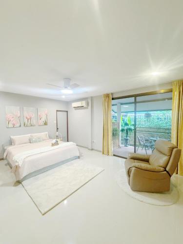 パタヤ・セントラルにあるSun and Moon Houseの白いベッドルーム(大型ベッド1台、椅子付)