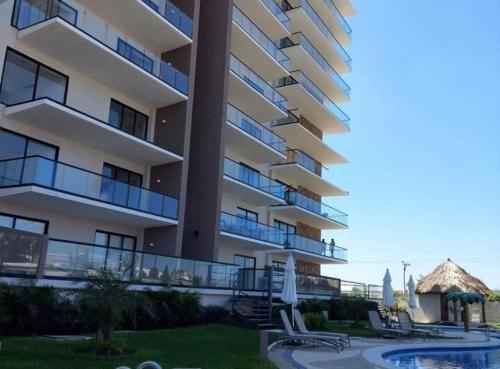 an apartment building with a swimming pool and a resort at Descanso en ACAPULCO DIAMANTE in Acapulco