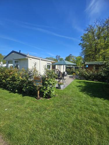 a house with a yard with a sign in the grass at Vechtdal Beerze Buren 2 in Beerze