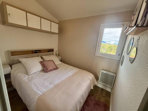 une petite chambre avec un lit et une fenêtre dans l'établissement Sublime T2 Mezzanine rénové, climatisé, parking - Argelès-sur-Mer - FR-1-388-235, à Argelès-sur-Mer
