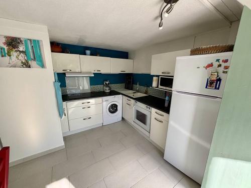 - une cuisine avec des appareils électroménagers blancs et des murs bleus dans l'établissement T2 Mezzanine Climatisé - 250m Mer - Argelès-sur-Mer - FR-1-388-236, à Argelès-sur-Mer