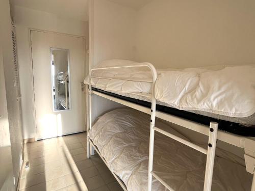 - 2 lits superposés dans une petite chambre avec couloir dans l'établissement Studio Cabine Accès Plage - Résidence Sécurisée avec Piscine - FR-1-753-31, à Saint-Cyprien