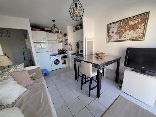 un salon avec une table et un canapé dans l'établissement Appartement à 50m de la plage avec parking et Wi-Fi - FR-1-482-155, à Fort-Mahon-Plage